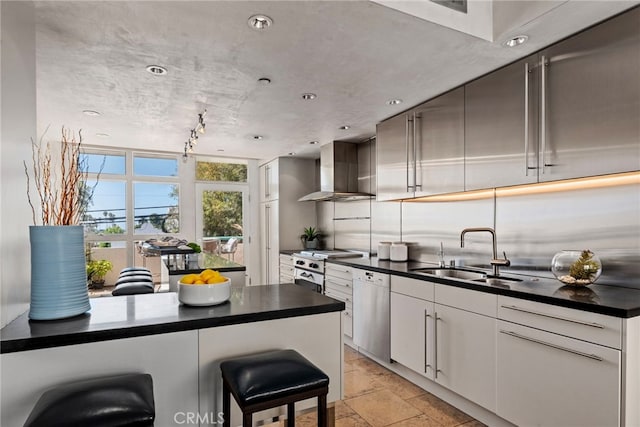 kitchen with a kitchen bar, wall chimney exhaust hood, sink, white dishwasher, and white cabinets