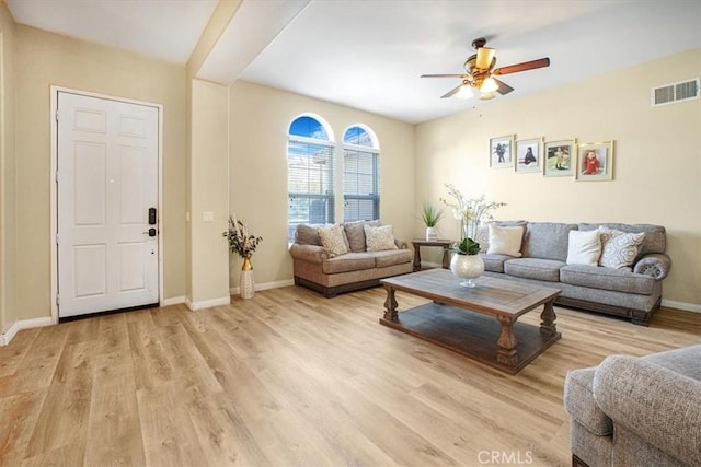 living room with a ceiling fan, baseboards, visible vents, and light wood finished floors