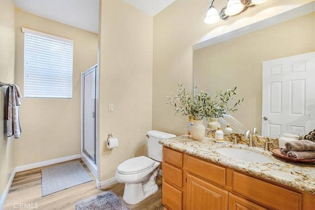 full bath featuring toilet, a shower stall, vanity, and wood finished floors