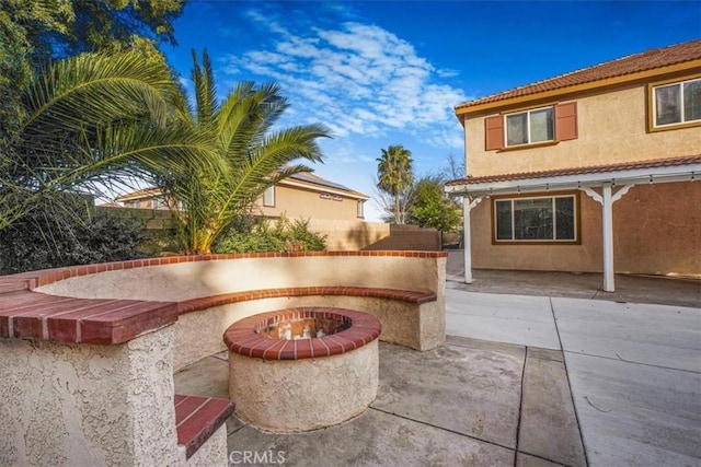 view of patio / terrace featuring fence and a fire pit