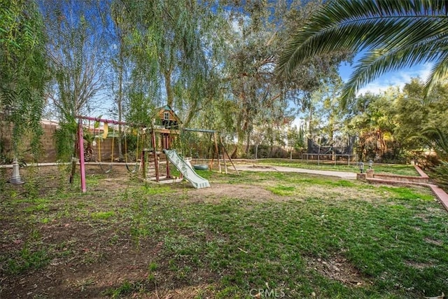 view of play area with a trampoline, fence, and a lawn