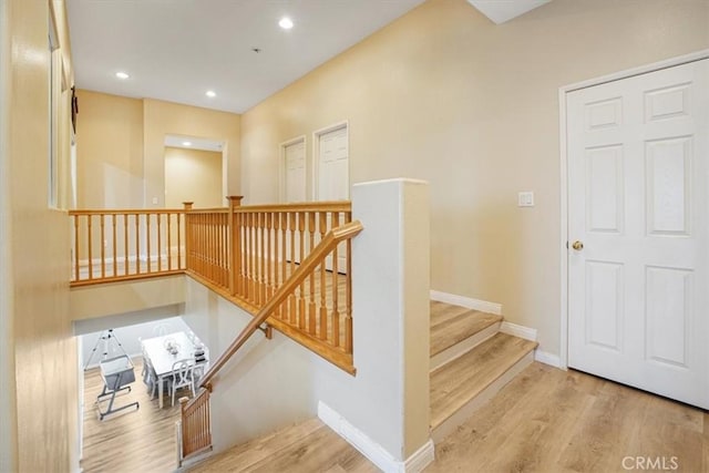 staircase featuring recessed lighting, baseboards, and wood finished floors