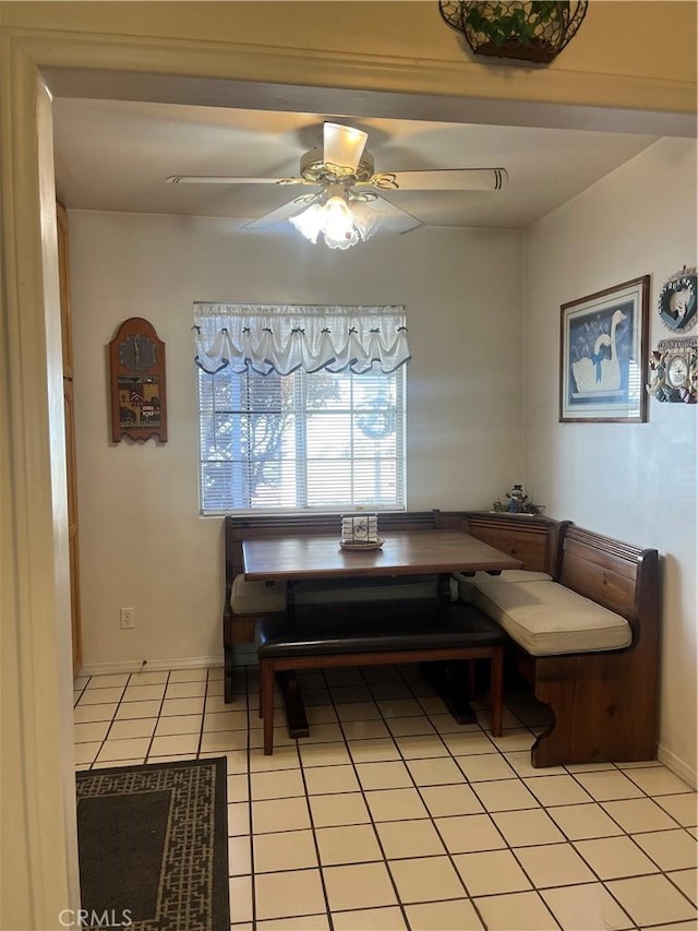 dining area with breakfast area, light tile patterned floors, baseboards, and a ceiling fan