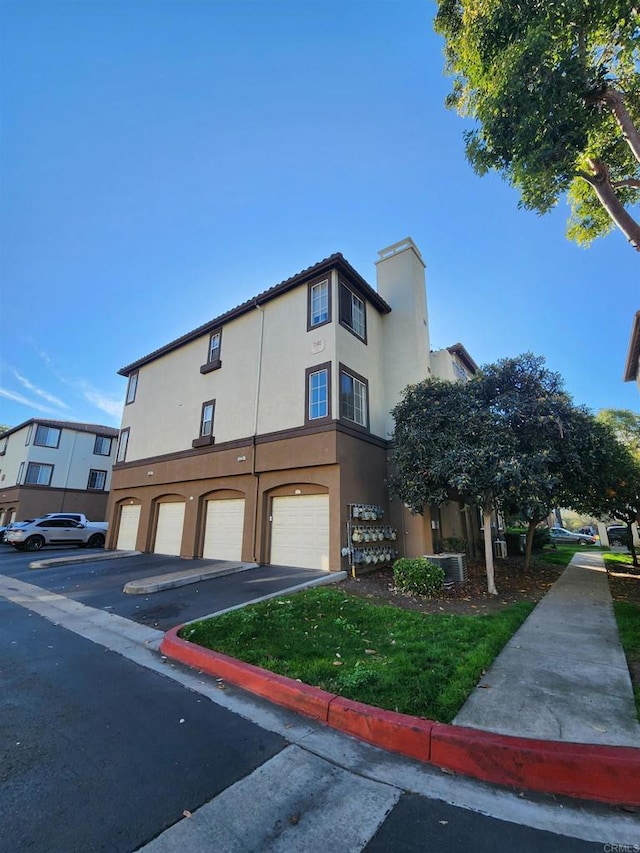 view of front of home featuring a garage and central air condition unit