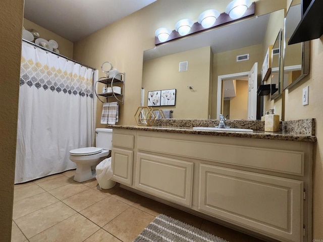 bathroom with tile patterned flooring, vanity, and toilet