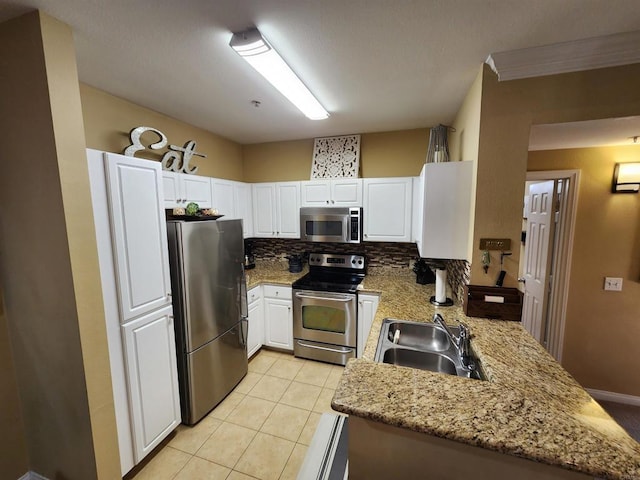 kitchen with sink, tasteful backsplash, appliances with stainless steel finishes, kitchen peninsula, and white cabinets