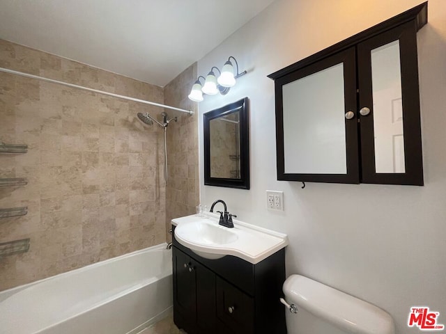 full bathroom with tiled shower / bath, vanity, and toilet