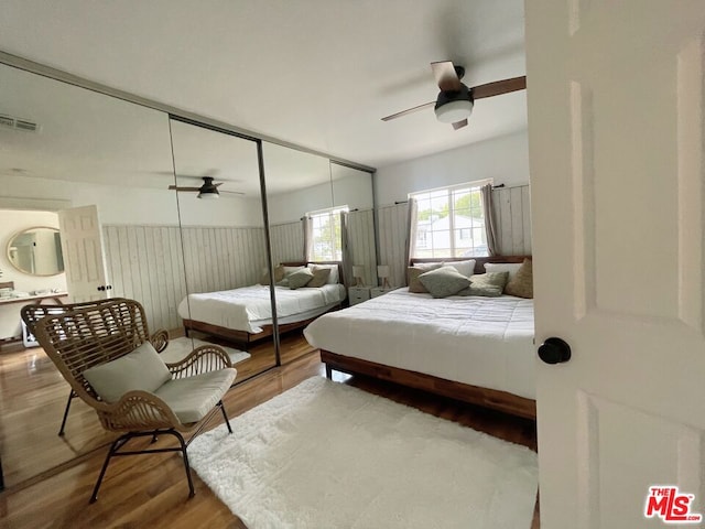 bedroom with wood-type flooring, ceiling fan, and a closet