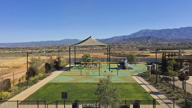 surrounding community with a mountain view, a lawn, and a playground