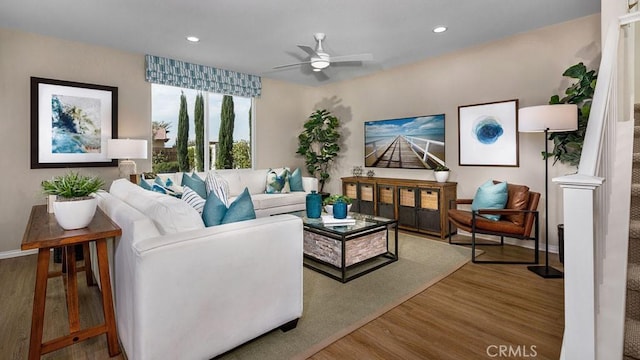 living room featuring wood-type flooring and ceiling fan