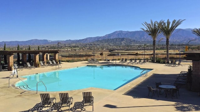 view of swimming pool with a mountain view and a patio