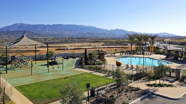 view of swimming pool featuring a mountain view and a playground