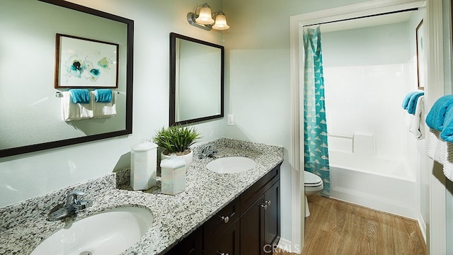 full bathroom featuring vanity, wood-type flooring, shower / bath combo, and toilet