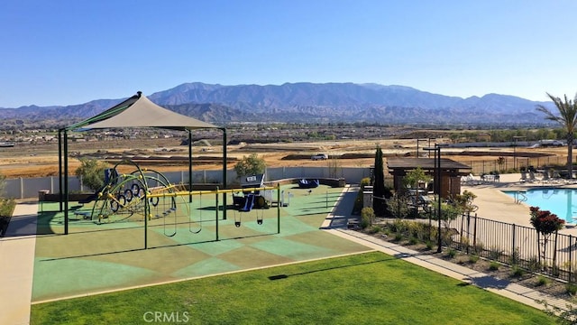 surrounding community featuring a playground, a mountain view, and a swimming pool