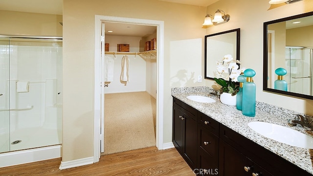 bathroom with vanity, hardwood / wood-style flooring, and walk in shower