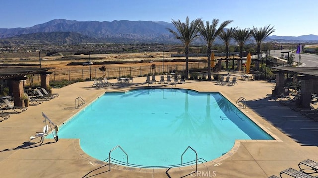 view of swimming pool with a mountain view and a patio