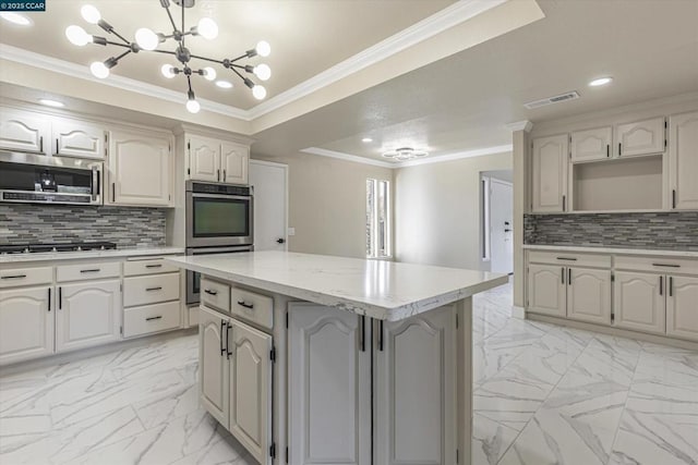 kitchen featuring crown molding, stainless steel appliances, a center island, and backsplash