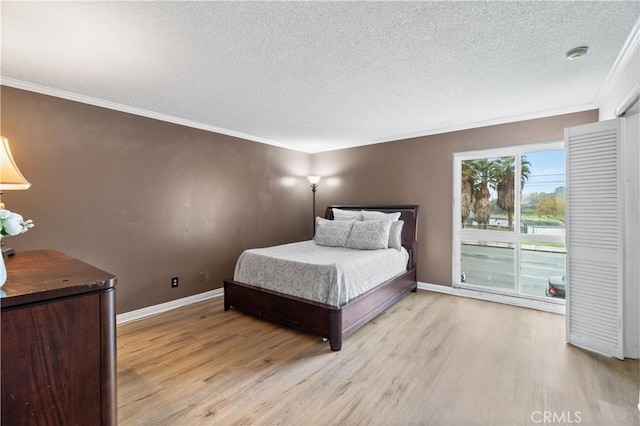 bedroom featuring ornamental molding, access to exterior, a textured ceiling, and light wood-type flooring