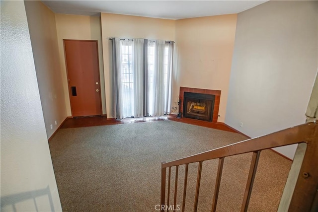 unfurnished living room with dark carpet and a tile fireplace