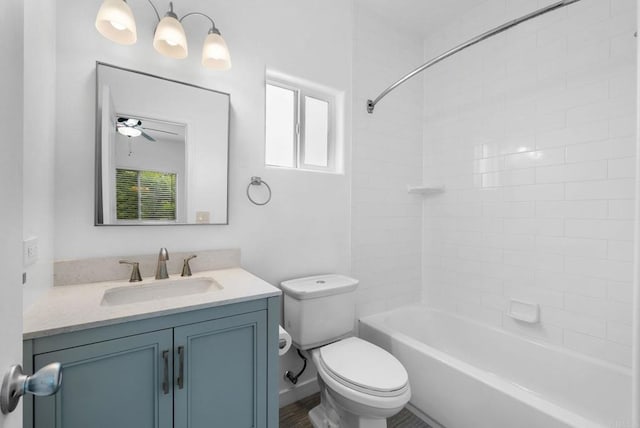 full bathroom featuring ceiling fan, tiled shower / bath, vanity, and toilet