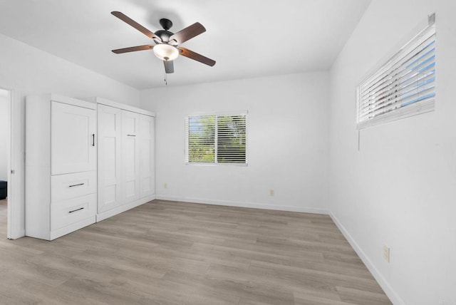 unfurnished bedroom featuring ceiling fan, light hardwood / wood-style floors, and a closet