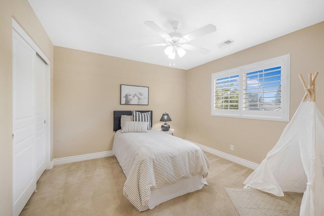 carpeted bedroom with ceiling fan and a closet