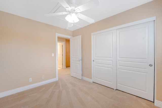 unfurnished bedroom featuring light carpet, ceiling fan, and a closet