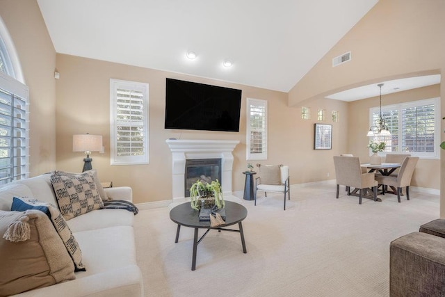 living room featuring high vaulted ceiling and carpet