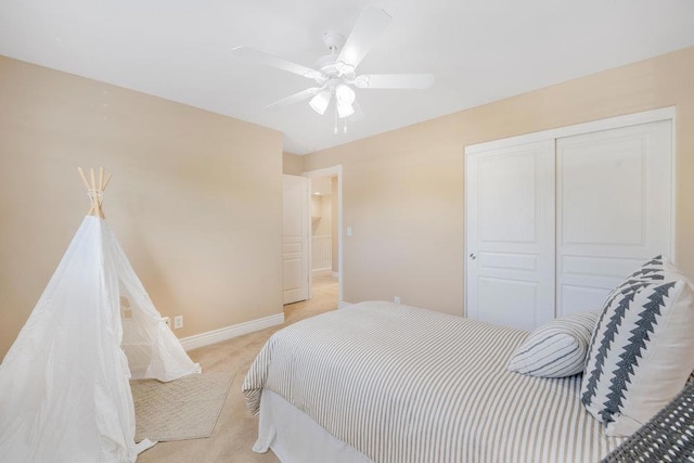 carpeted bedroom with ceiling fan and a closet