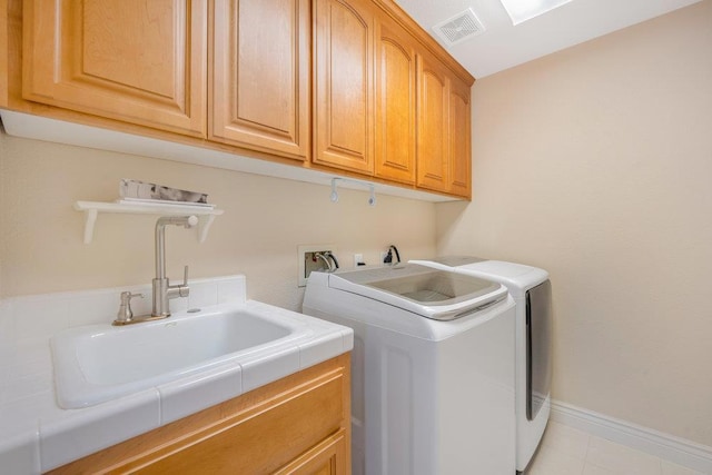 laundry room with independent washer and dryer, cabinets, light tile patterned flooring, and sink