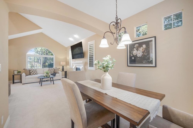 dining room featuring a notable chandelier, high vaulted ceiling, and carpet