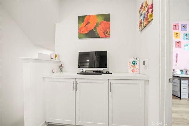 bar featuring white cabinets and light hardwood / wood-style floors