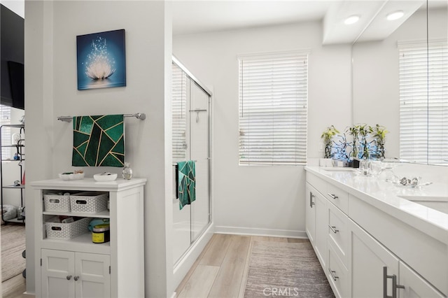 bathroom with vanity, a shower with door, hardwood / wood-style floors, and plenty of natural light