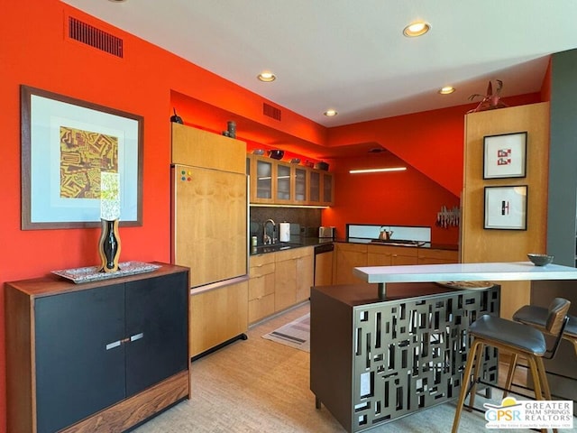 kitchen featuring sink, paneled refrigerator, light carpet, decorative backsplash, and stainless steel dishwasher