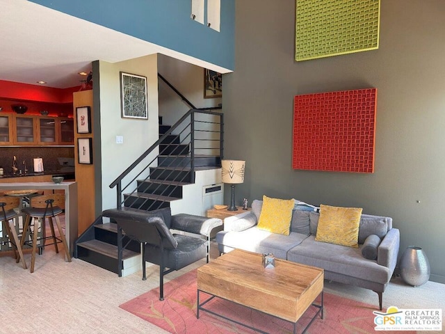 carpeted living room featuring a high ceiling