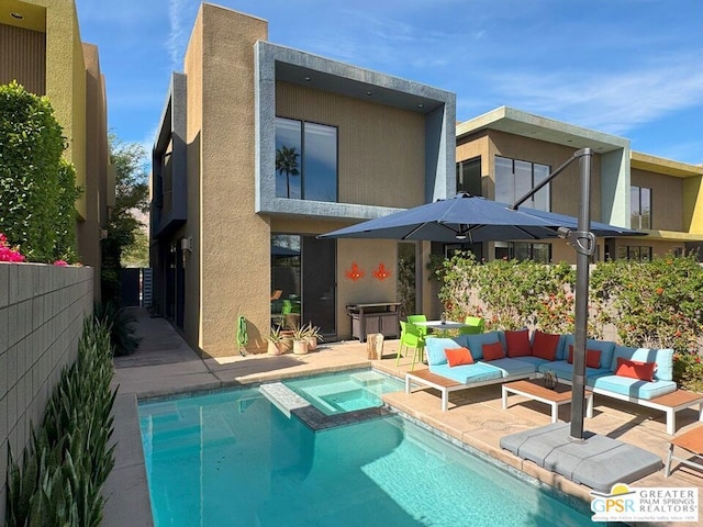 rear view of house with a swimming pool with hot tub, a patio, and an outdoor hangout area