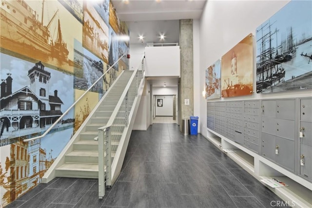 stairs featuring a towering ceiling and a mail area