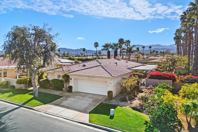 view of front of house featuring a garage, a mountain view, and a front yard