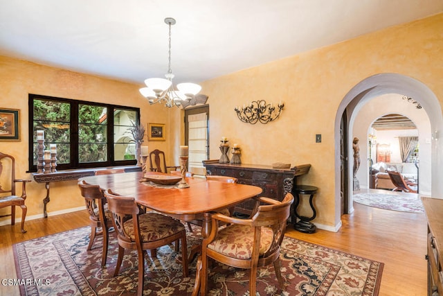 dining area featuring light hardwood / wood-style floors and a chandelier