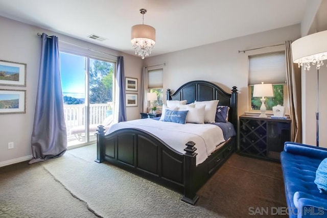 carpeted bedroom featuring a notable chandelier and access to outside