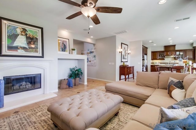 tiled living room featuring sink and ceiling fan