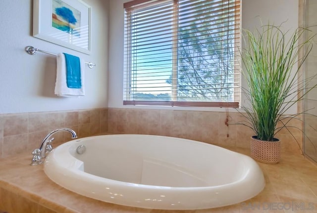 bathroom with a relaxing tiled tub