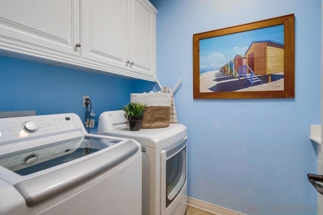 laundry area featuring cabinets and washing machine and clothes dryer