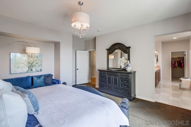 bedroom with a notable chandelier and dark colored carpet