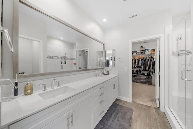 bathroom featuring walk in shower and vanity