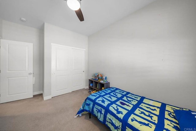 carpeted bedroom with vaulted ceiling, ceiling fan, and a closet