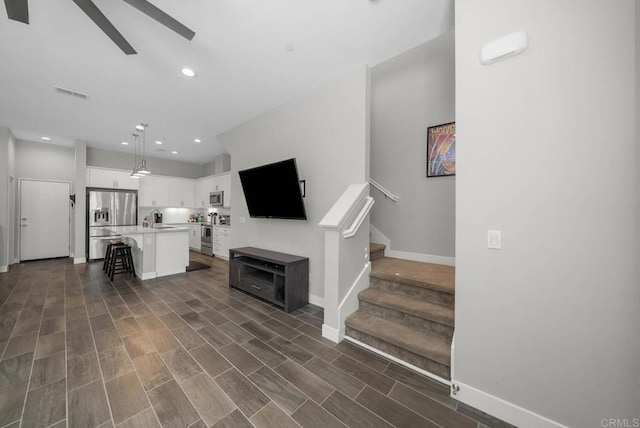 living room featuring ceiling fan, dark hardwood / wood-style flooring, and sink