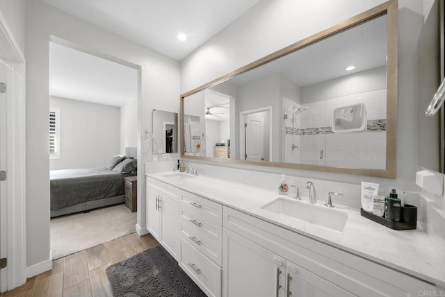 bathroom with vanity, a shower with shower door, and ceiling fan