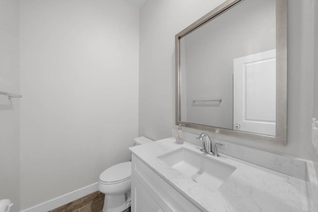 bathroom featuring vanity, wood-type flooring, and toilet