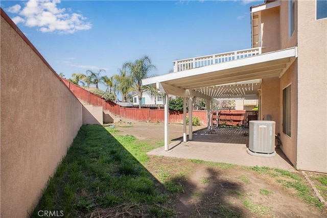 view of yard featuring a patio area, a pergola, a fenced backyard, and central AC unit